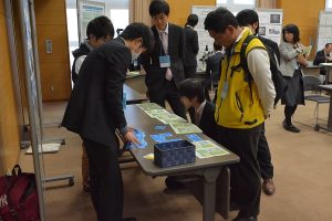 本学大学院生が開発したカードゲーム教材をプレゼンする様子