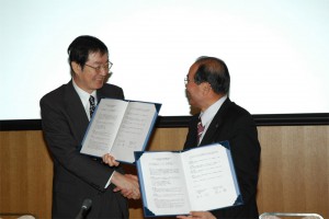 調印後、にこやかに握手を交わす福田学長と黒田福井県眼鏡工業組合理事長