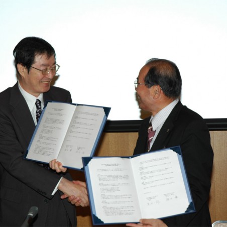 調印後、にこやかに握手を交わす福田学長と黒田福井県眼鏡工業組合理事長