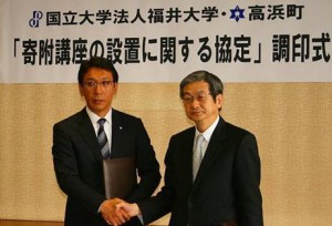 協定書を取り交わした後、握手する野瀬町長（左）と上田医学部長（右）