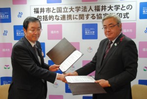 福井市長と協定書を交換し、握手を交わす福田学長（左）